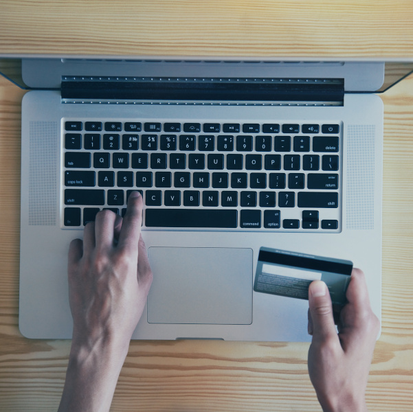 Hands holding credit card and using laptop. View from above